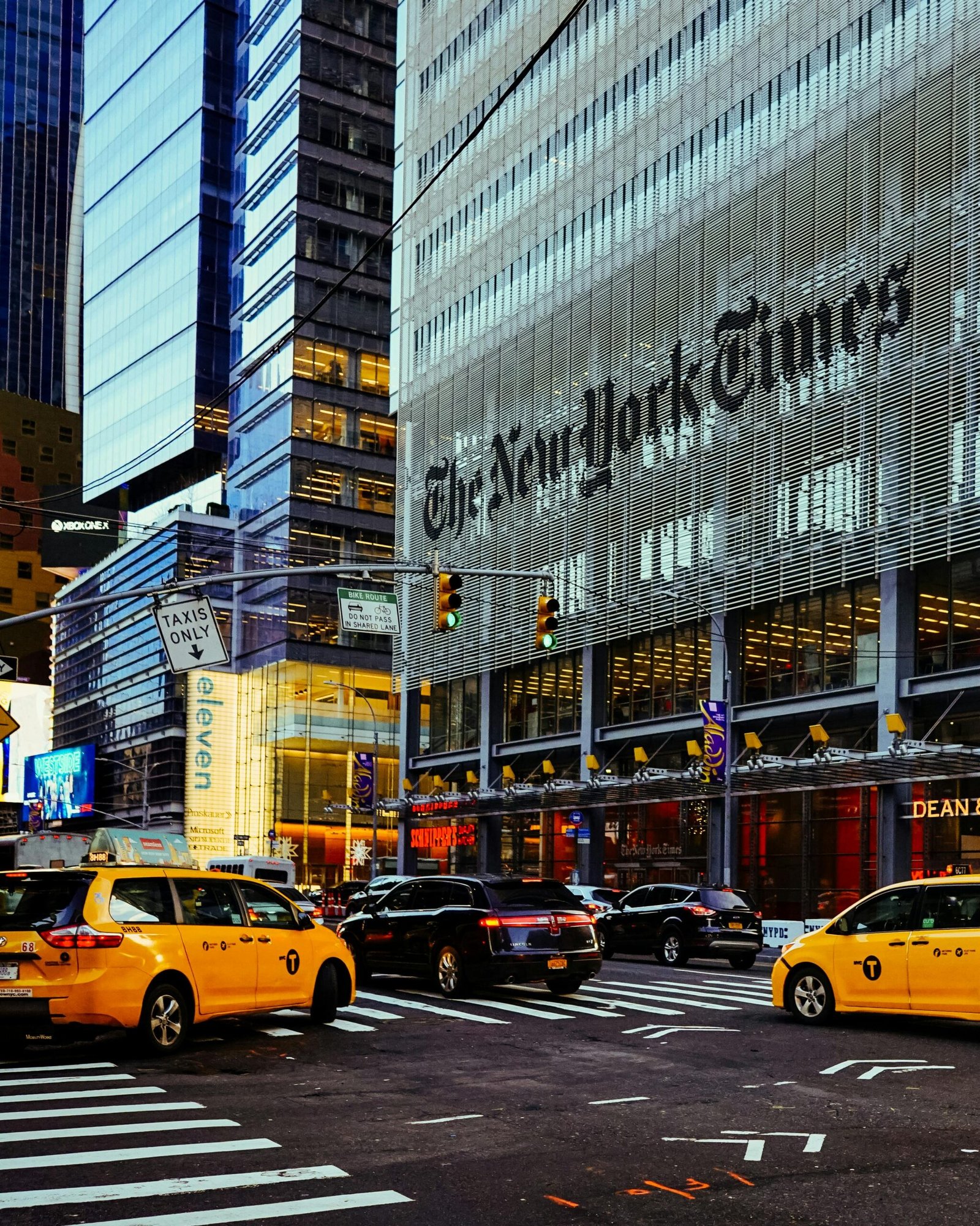 Street view of the New York Times Building surrounded by taxis in bustling New York City.